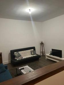 a living room with a couch and a tv at Superbe appartement avec parking gratuit in Vaulx-en-Velin