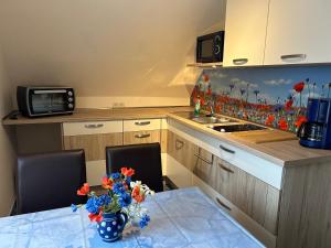 eine Küche mit einem Tisch und einer Blumenvase darauf in der Unterkunft Ferienwohnung Familie Petschel in Kurort Jonsdorf