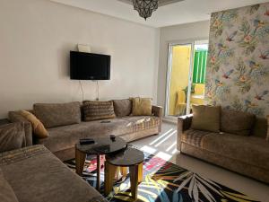 a living room with two couches and a tv at Lovely city center flat near the old Medina in Casablanca