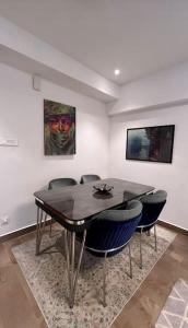 COZY & Serene Home في آكرا: غرفة طعام مع طاولة وكراسي ولوحة