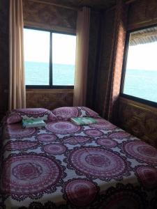 a bedroom with a bed with a view of the ocean at Shey's Travellers Inn in Mambajao