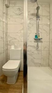 La salle de bains blanche est pourvue d'une douche et de toilettes. dans l'établissement The Fairhaven Hotel, à Weymouth