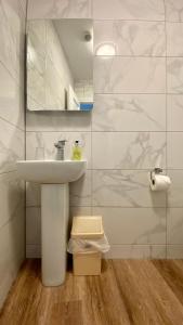 La salle de bains blanche est pourvue d'un lavabo et d'un miroir. dans l'établissement The Fairhaven Hotel, à Weymouth