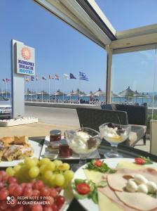 a table with plates of food on the beach at GOLDEN SUN Κokkoni Beach Hotel in Vrahati