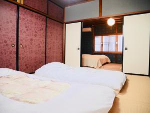 1 dormitorio con 2 camas y ventana en Folksy House / Vacation STAY 64171 en Izumo