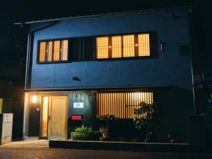 um edifício azul com duas janelas e uma porta em Folksy House / Vacation STAY 64171 em Izumo