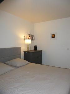 sypialnia z łóżkiem i lampką na komodzie w obiekcie Appartement terrasse daumesnil w Paryżu