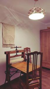 uma mesa de madeira com duas cadeiras e um candeeiro em Chwile w Starym Sączu, sauna i beczka em Stary Sacz