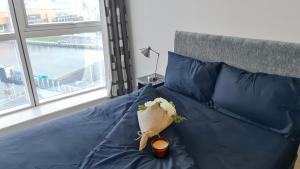 貝爾法斯特的住宿－River View Private Room in Shared Apartment，一张带鲜花的蓝色棉被的床