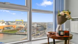 a table with a vase of flowers on it next to a window at River View Private Room in Shared Apartment in Belfast