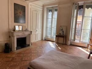 Cette chambre dispose d'une cheminée et d'un lit. dans l'établissement Chambre spacieuse dans magnifique appartement XVII, à Grenoble