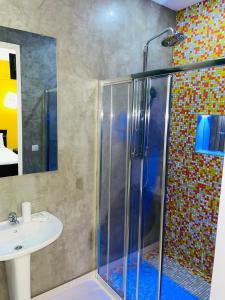 a bathroom with a shower and a sink at Residencial Sol Point Art in Ponta do Sol