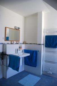 a bathroom with a white sink and blue towels at Ferienwohnung "Alte Fischerei" in Ketzin