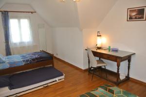Dormitorio con cama, escritorio, cama y escritorio en Gîte Les Chênes, en Villeneuve-les-Sablons