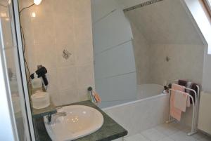 a bathroom with a sink and a bath tub at Gîte Les Chênes in Villeneuve-les-Sablons +10 photos
