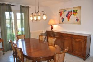 comedor con mesa de madera y sillas en Gîte Les Chênes, en Villeneuve-les-Sablons