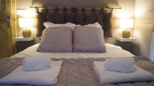 a bed with two pillows on it with two lamps at Gite de Mortagne, Chalet avec Piscine - BY PRIMO C0NCIERGERIE in Gigny-sur-Saône