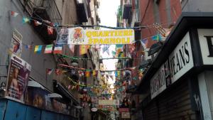 a narrow street with a sign for an outdoorariariari shop at Hotel Il Convento in Naples