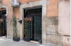 un bâtiment avec des plantes en pot devant une porte dans l'établissement Little Loft 14 appartamento vicino il centro di Bari, à Bari
