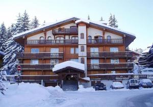 a large building with cars parked in the snow at Résidence Les Sapins - Courchevel 1850 in Courchevel