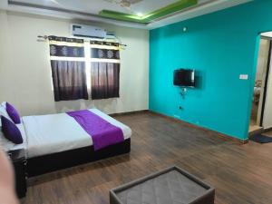 a bedroom with a bed and a tv in it at Vijay Gardens in Pulivendla