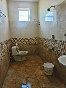 a bathroom with a toilet and a sink at Vijay Gardens in Pulivendla