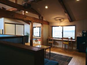 Kura kawamukai / Vacation STAY 35227 في إزومو: غرفة معيشة مع طاولة وبعض النوافذ