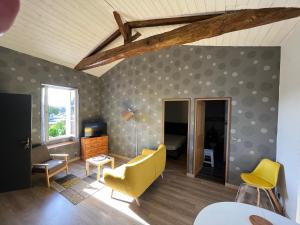 ein Wohnzimmer mit einem gelben Stuhl und einer Couch in der Unterkunft ALS locations calvet françoise in Jonzac