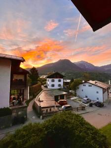 a sunset over a town with a parking lot and mountains at Bergsteigerzimmer Doktorberg in Berchtesgaden