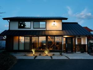 una casa con techo negro y ventanas de cristal en Kura kawamukai / Vacation STAY 35227 en Izumo
