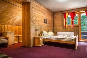 ein Schlafzimmer mit einem Bett in einem Holzzimmer in der Unterkunft Chata Liptov in Liptovský Ján