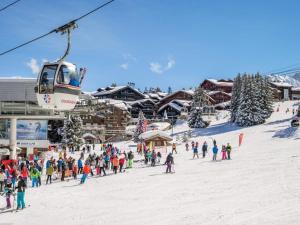 a group of people on a ski slope with a ski lift at Résidence Les Sapins - Courchevel 1850 in Courchevel