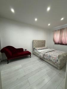 a bedroom with two beds and a red couch at Cheerful 2 Bedroom Bungalow fully Furnished in Bradenham