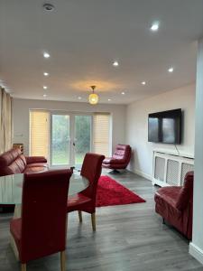 uma sala de estar com uma mesa e cadeiras e uma televisão em Cheerful 2 Bedroom Bungalow fully Furnished em Bradenham