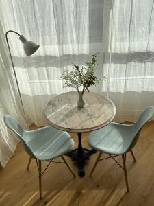 a table with two chairs and a vase with flowers at Plaza Tomás in Pamplona