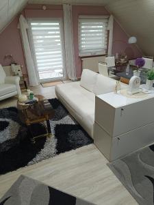 a living room with a white couch and a table at Ferienwohnung Schwalmstadt in Schwalmstadt