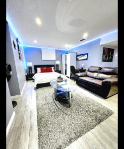 uma sala de estar com uma cama e um sofá em Staycation Apartment, Free Parking ,kitchen & washroom ensuite em London