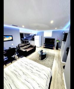 a bedroom with a large bed and a living room at Staycation Apartment, Free Parking ,kitchen & washroom ensuite in London