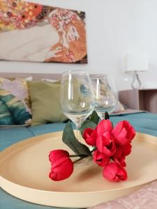 un piatto con un bicchiere di vino e fiori rossi su un tavolo di Casaagnese a Catania