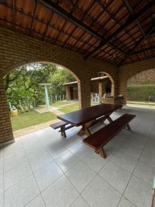 einen Picknicktisch und zwei Bänke auf einer Terrasse in der Unterkunft Casa na serra de mulungu in Mulungu