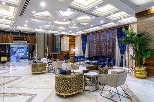 a lobby with chairs and tables and a piano at Crown Rose AlSahafa Hotel in Riyadh