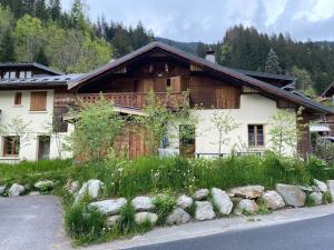 a wooden house with rocks in front of it at Joyeux Flocon - Spacieux chalet in Les Contamines-Montjoie