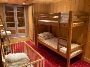 a room with two bunk beds in a cabin at Joyeux Flocon - Spacieux chalet in Les Contamines-Montjoie