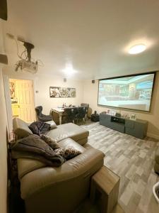 a living room with a couch and a projection screen at TJ House in Sherborne Saint John