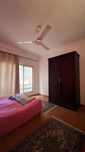 una camera con letto e ventilatore a soffitto di Super Cozy Apt 7 min to CAI a Il Cairo
