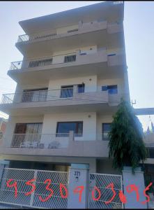 un grand bâtiment blanc avec un arbre devant lui dans l'établissement snooze 3, à Panchkula