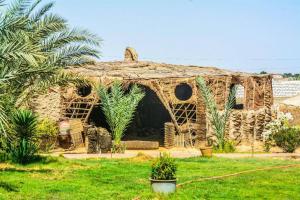 ein altes Steinhaus auf einem Grasfeld in der Unterkunft Sand Rose Bahriya Hotel in Bawati