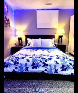 Un dormitorio con una cama con luces azules. en Staycation Apartment, Free Parking ,kitchen & washroom ensuite en Londres