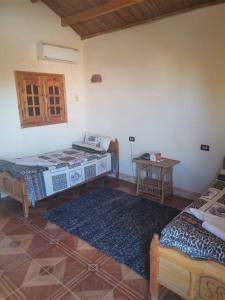 Zimmer mit 2 Betten und einem Tisch in der Unterkunft Sand Rose Bahriya Hotel in Bawati