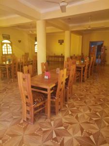ein Esszimmer mit einem Holztisch und Stühlen in der Unterkunft Sand Rose Bahriya Hotel in Bawati